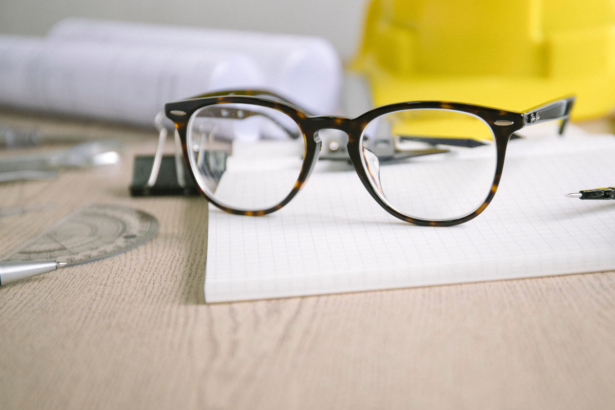 Eyeglass frames resting on a desk before lens replacement